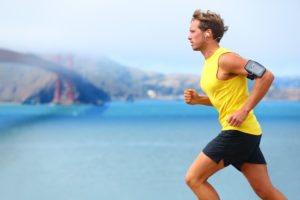 Athlete running man - male runner in San Francisco listening to